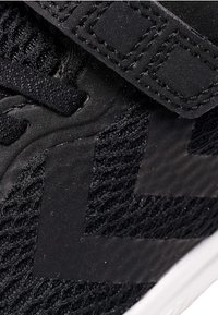 Scarpe sportive nere con tomaia in rete, dettagli in gomma e cinturino in Velcro. Presentano un tessuto testurizzato e sezioni lisce per creare un contrasto.