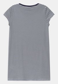 T-shirt i bomull med korta ärmar, med horisontella marinblå och vita ränder, rund halsringning och en avslappnad passform.