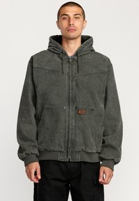 Dark grey hooded jacket made of textured fabric, featuring a front zipper, two side pockets, and elasticized cuffs and hem.