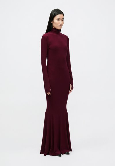 Marl burgundi värvi, pikkade varrukatega kõrge kaelusega kleit, millel on liibuv korsett ja lehvikseelik. Sile tekstuur ja pahkluuni ulatuv pikkus peente detailidega.