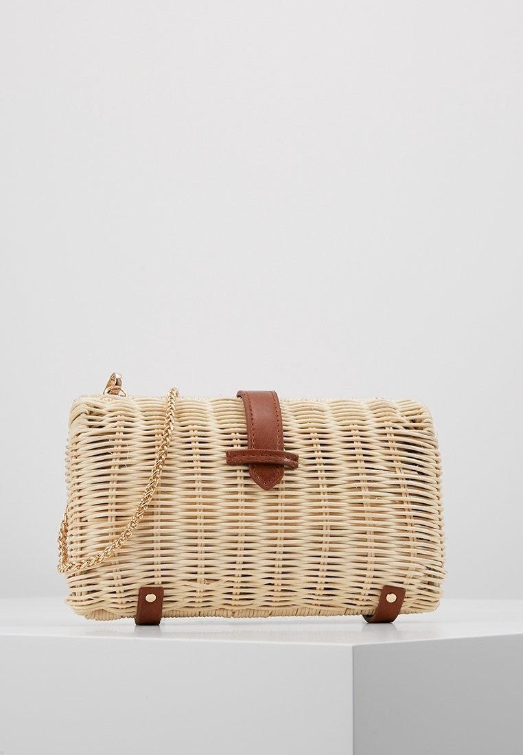 Woven straw handbag with a rectangular shape, leather accents, and a gold chain strap. The surface has a natural texture and light color.