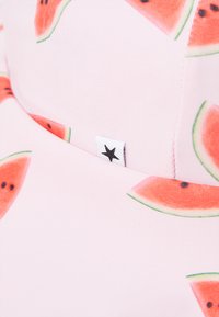 Pink fabric featuring a watermelon pattern with green edges and black seeds. A small tag with a star logo is visible on the side.