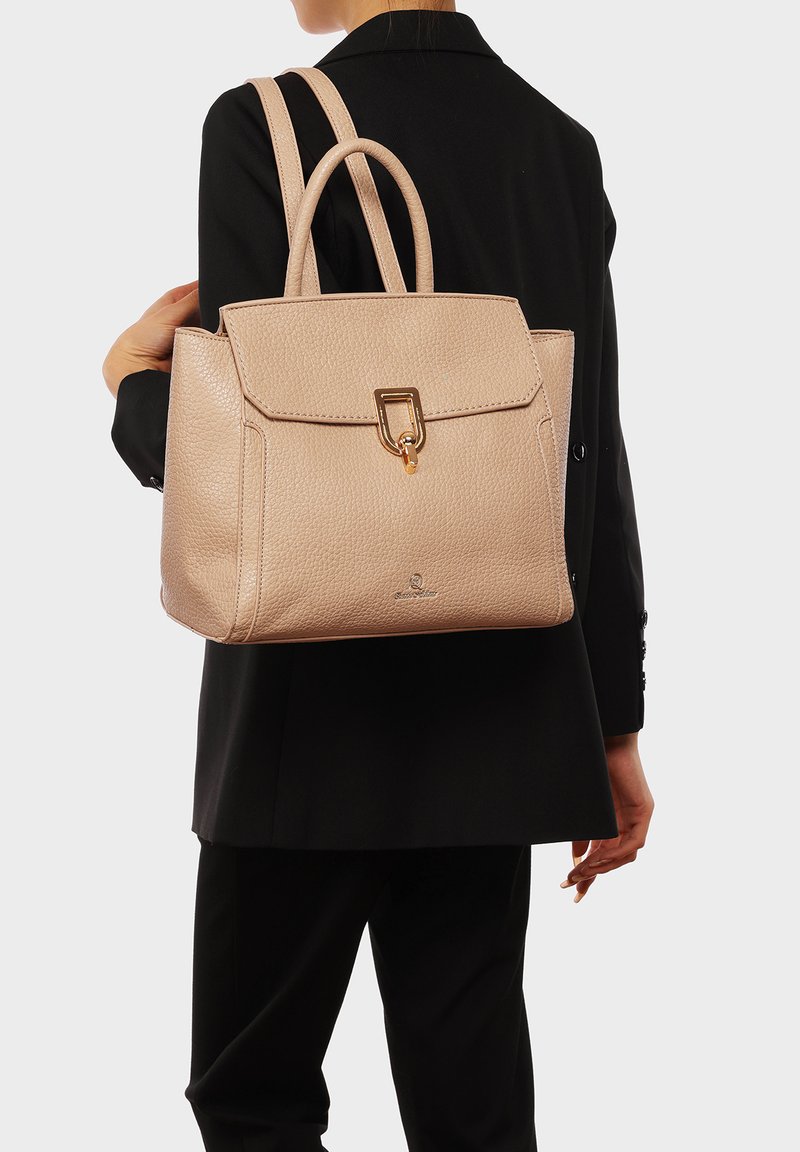 Borsa a mano in pelle beige con forma strutturata, manici superiori, chiusura a scatto e finitura testurizzata delicata. Sono visibili dettagli in hardware dorato.
