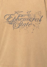 Beige sweatshirt med et falmet mørkeblåt grafisk print med teksten "Ephemeral State" og stjernedesign. Blød texture, afslappet design.
