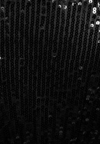 Tissu noir densément recouvert de rangées verticales de petits sequins noirs brillants reflétant la lumière.
