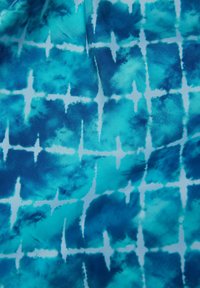 Textil s modro a tyrkysově zbarveným akvarelovým vzorem, který obsahuje bílé křížové čáry. Měkká textura s tekutým, jemně spojeným designem.