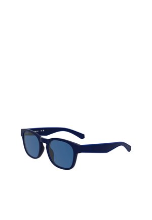 Des lunettes de soleil bleu marine avec des verres rectangulaires, des montures plus épaisses et des teintes de bleu contrastantes. Elles présentent une finition mate et un design de branches courbées.