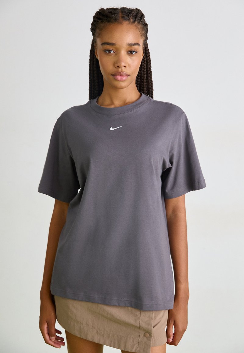 Grå bomull t-skjorte med korte ermer og rund hals, med en liten hvit Nike-logo på brystet.