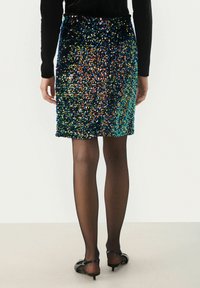 Sukňa s flitrami s multicolornými, lesklými ozdobami rôznych veľkostí. Má priliehavý strih, textúrovaný povrch a elastický pás.