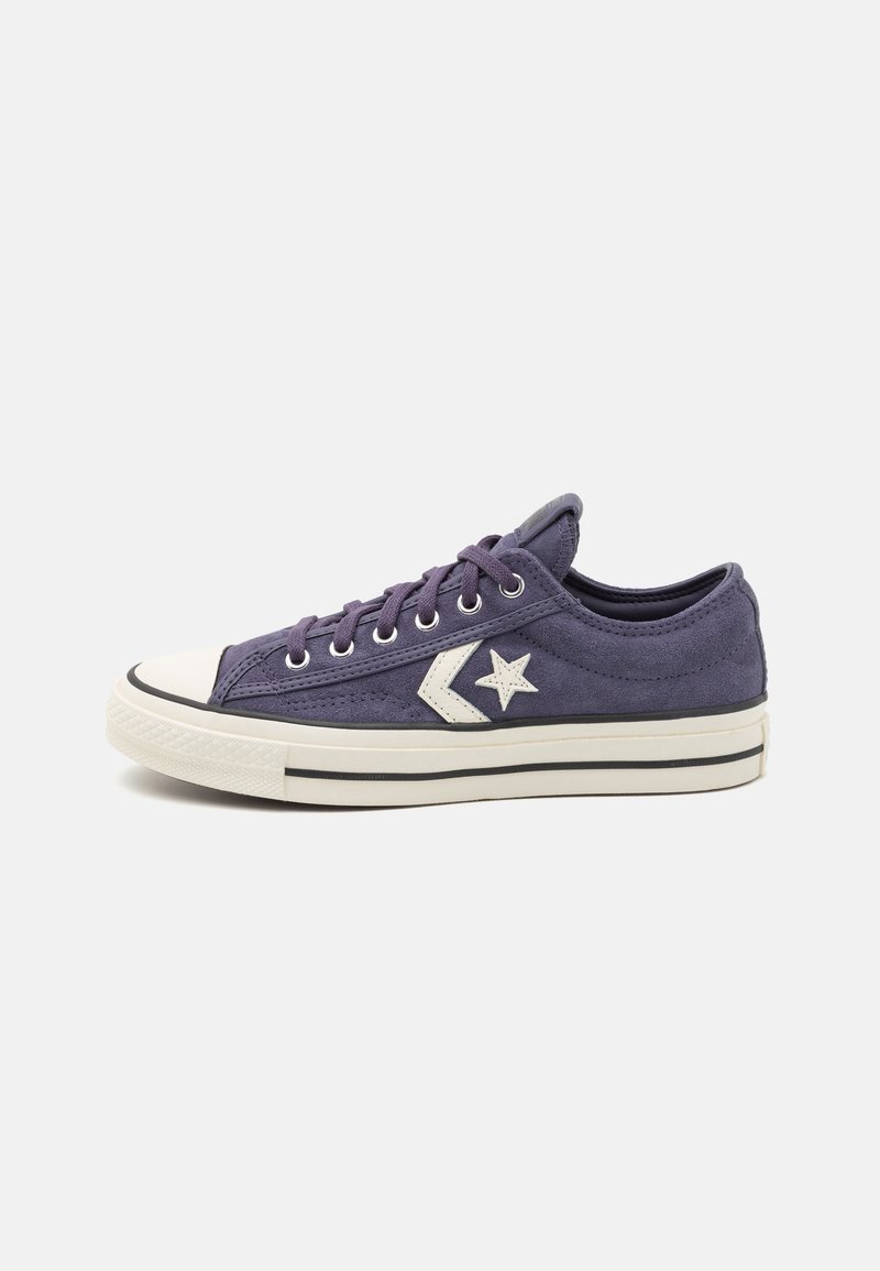 Adidași din pânză mov cu logo alb în formă de stea și accente gri închis, având un vârf din cauciuc și un design cu tăiere joasă.