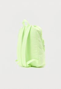 Ανοιχτό πράσινο σακίδιο με δύο επενδυμένους ιμάντες ώμου, χειρολαβή στο πάνω μέρος και ορατή τσέπη με φερμουάρ σε απλό λευκό φόντο.