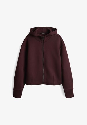 Burgundy zip-up hoodie with a hood, made of soft fabric, featuring relaxed fit, dropped shoulders, and side slits at the hem.