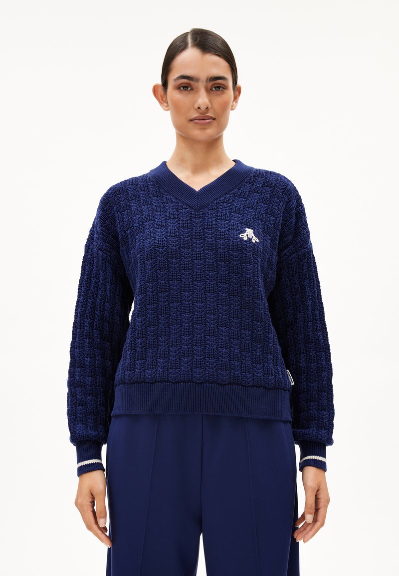Marineblauer Strickpullover mit strukturiertem Muster, V-Ausschnitt und gerippten Bündchen. Gesticktes Logo auf der Brust. Lässig geschnitten.
