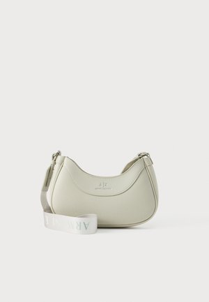 Small off-white leather shoulder bag with curved shape and wide white strap printed with "ARMANI EXCHANGE" laid in front.