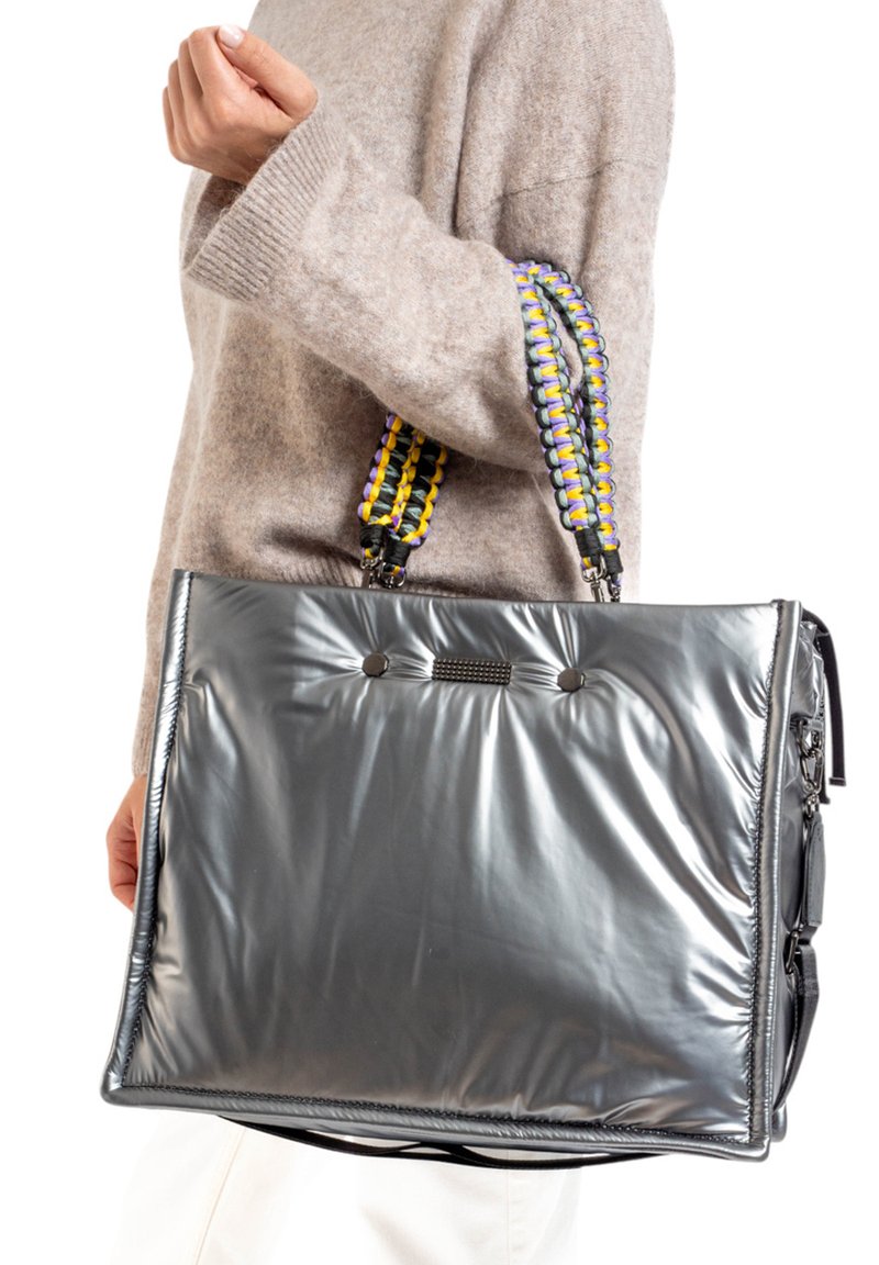 Sac fourre-tout gris rembourré avec une surface texturée, featuring des poignées tressées en jaune et violet, et deux accents de bouton noir à l'avant.