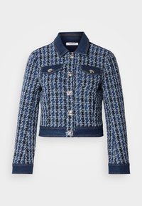 veste en denim avec un motif tissé texturé bleu et noir, boutons en argent, deux poches poitrine et des accents en denim au niveau du col et de l'ourlet.