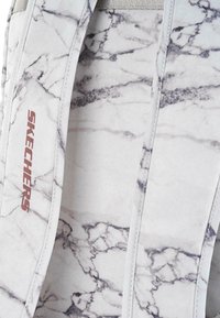 Mochila Skechers con un patrón de mármol blanco y gris, que presenta un tejido suave, correas resistentes y un sutil detalle del logotipo.