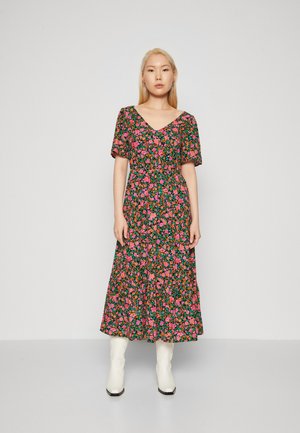 Robe à fleurs avec un fond noir et des fleurs colorées roses et vertes, décolleté en V, manches courtes et longueur midi fluide.