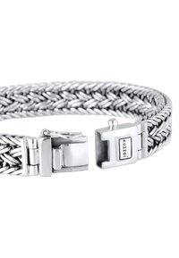 Silver färgad vriden metallarmband med en texturerad design, med en låsning och graverad "Kuzzoi"-logotyp på hårdvaran.