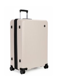 Hard-shell suitcase in light beige with vertical ribbed texture, black zipper, and a telescopic handle. Features four black wheels for mobility.