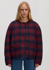 Rood en marineblauw geruit jack met een afgeronde kraag, knoopsluiting aan de voorkant en twee zijzakken, gemaakt van een gestructureerde stof. Losvallende pasvorm.