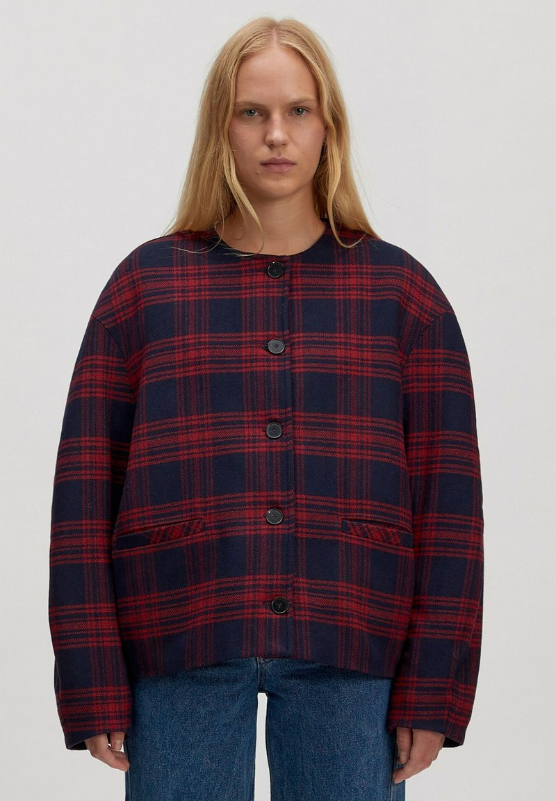 Rood en marineblauw geruit jack met een afgeronde kraag, knoopsluiting aan de voorkant en twee zijzakken, gemaakt van een gestructureerde stof. Losvallende pasvorm.