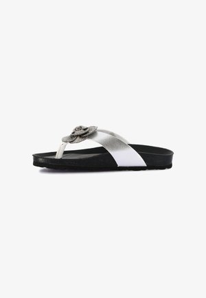 Sandalo con suola nera, cinturino argento metallizzato e infradito decorato con ornamento floreale tempestato di strass su sfondo bianco.