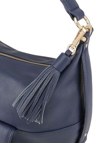 Marineblauwe leren handtas met een gestructureerde afwerking, goudkleurige accenten en een decoratieve leren kwast aan de schouderband.