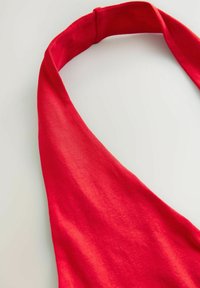 Sarkanais audums halter top ar gludu tekstūru, ar plašu, izliekta izgriezuma dizainu un bezšuvju izskatu. Bez redzamām detalēm vai aksesuāriem.