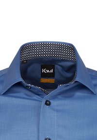Camicia moderna blu con colletto a righe nere e bianche texture, con bottoni neri e un'etichetta con scritto "Kauf". Taglia 38.