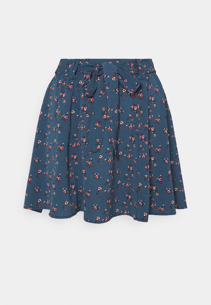 Jupe évasée bleue avec petit motif floral rouge et blanc, taille haute, passants de ceinture et ceinture en tissu nouée à l'avant.