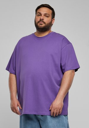 T-shirt surdimensionné violet en coton, avec un col rond et des manches courtes. Texture lisse avec une coupe décontractée.