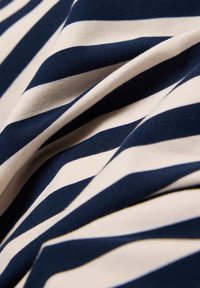 Navy and cream striped fabric, featuring horizontal stripes with a smooth texture, folded to showcase the pattern and material.