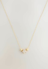 Złoty naszyjnik z centralnym zawieszeniem w kształcie gwiazdy, ozdobionym pięcioma przezroczystymi kamieniami szlachetnymi oraz dwoma akcentami w kształcie gwiazdy po obu stronach. Wzór łańcuszka typu cable.