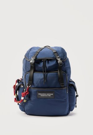 Donkerblauwe rugzak met meerdere met rits afsluitbare vakken, zwarte bandjes en een decoratieve rood-wit-blauwe koord aan de zijkant.