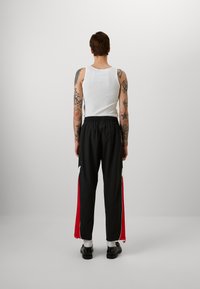 New Balance IN GAME - Pantalon de survêtement - black