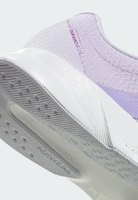 Gros plan sur le talon d'une chaussure de course lavande avec une semelle blanche texturée portant les inscriptions « ADIPRENE » et « DURAMO RC 2 » sur le côté.