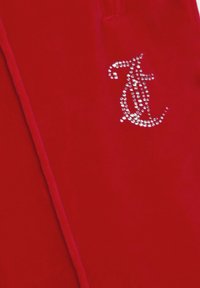 Jogging in velluto rosso con accento di logo in strass argentati. Il materiale ha una consistenza morbida e liscia e una vestibilità su misura.