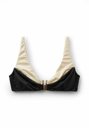 Tofarvet sort og beige bikinitop med tynde stropper og en guldfarvet frontspænde, lagt fladt på en hvid baggrund.