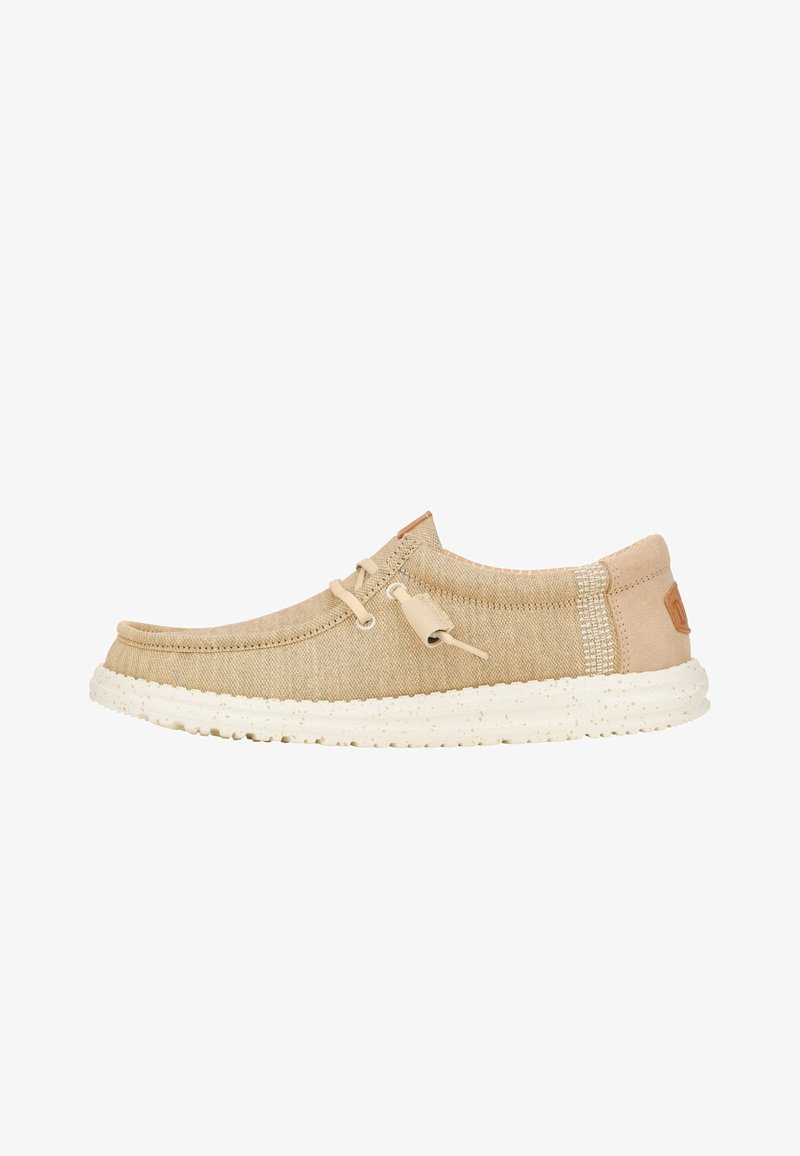 Beige Leinenschuh mit runder Zehenpartie, kontrastierenden strukturierten Akzenten, flachen Schnürsenkeln und einer Gummisohle mit Spritzern. Lederlogo an der Seite.