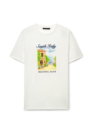 T-shirt blanc affichant une illustration colorée d'une rue ensoleillée du sud de l'Italie avec des plantes, un bateau et les textes « Sud de l'Italie » et « Endroit magnifique ».