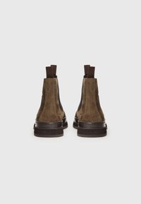 Brown suede ankle boots with elastic side panels, pull tabs, and a textured rubber sole. Smooth finish and rounded toe design.
