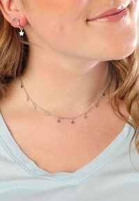 Silberschmuckset mit sternförmigen Anhängern. Die Halskette hat mehrere kleine Sterne, die von einer zarten Kette hängen, kombiniert mit passenden Sterneohrringen.
