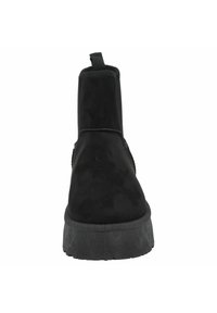 Botines de ante negros con suela plana negra, que cuentan con una tira de sujeción en la parte posterior para facilitar su uso. Textura suave y diseño minimalista.