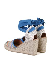 Wedge espadrilles hebben een geweven, multicolor textiel bovenkant, blauwe bandjes en een natuurlijke jute touwzool met een gestructureerde afwerking.