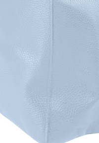 Sac en cuir texturé bleu clair de forme carrée, avec des coutures apparentes et une finition lisse. Aucun autre élément de quincaillerie ou détail de design visible.