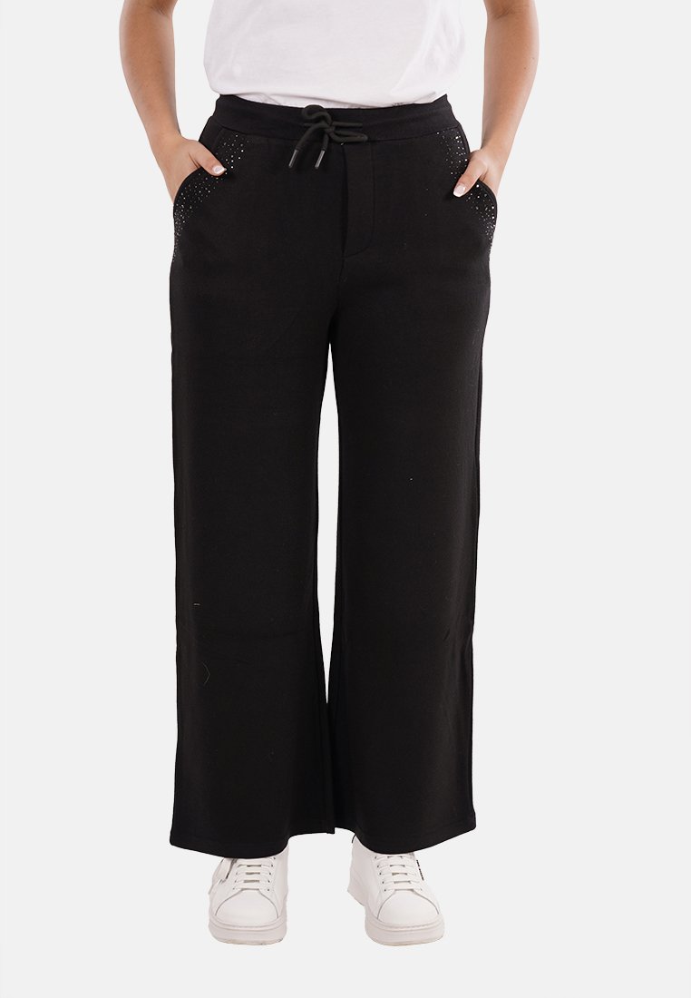 Pantaloni neri a gamba larga con vita regolabile, dotati di due tasche laterali rifinite con piccole borchie. Tessuto dalla texture liscia.