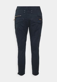 Pantalons bleu marine avec une conception de jambe fuselée. Deux poches arrière, poches zippées sur les côtés et détails de couture contrastants. Fabriqués en tissu durable.