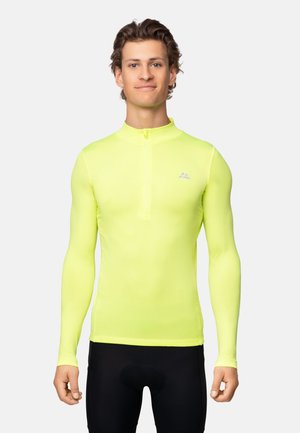 Chemise de sport à manches longues et zippée en tissu jaune vif, présentant une texture lisse et un petit logo sur la poitrine.