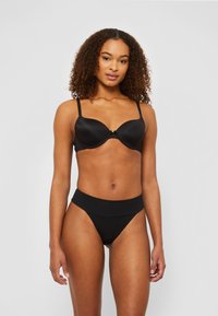 Black padded bra with adjustable straps and a bow detail at the center, paired with high-waisted black briefs, both made of smooth fabric.